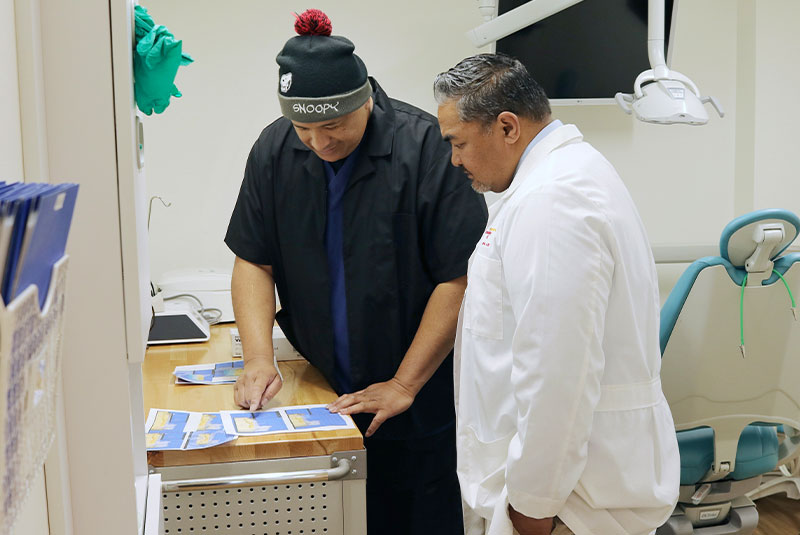 Doctor and staff member going over paper charts for dental procedure