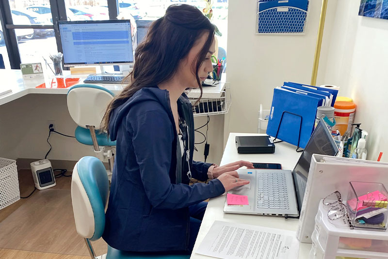 Staff member going over dental procedure work for patient within the dental practice